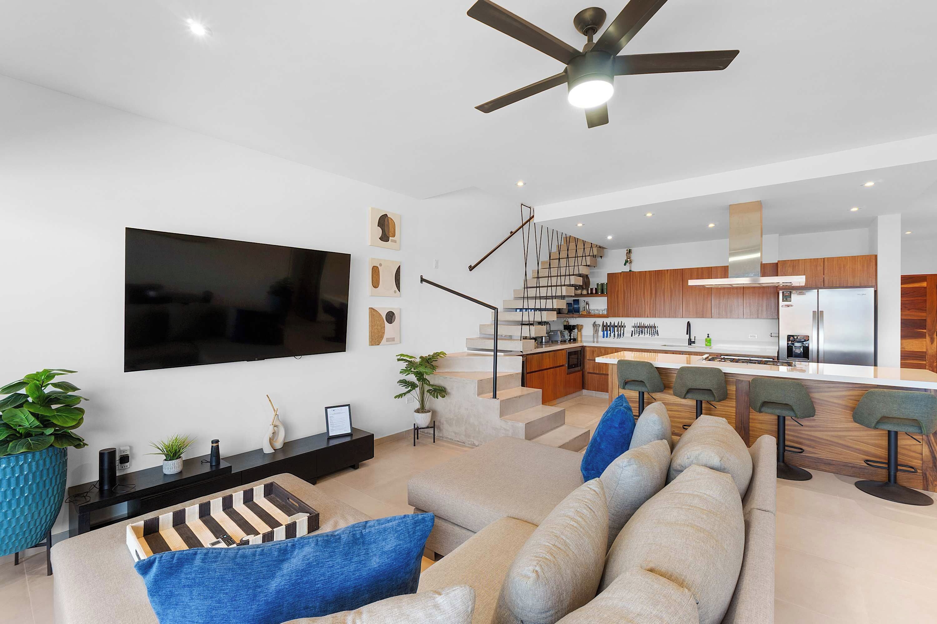 A modern living room with a large flat-screen TV, a sofa, and a coffee table.