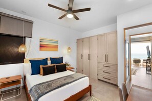 Una camera da letto con un letto, comodini, una ventola a soffitto, un quadro e un armadio.