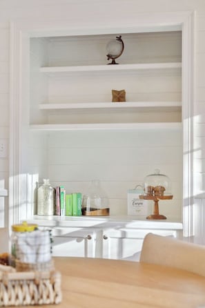 A white shelving unit with decorative items and books. - Quaint Cottage-Great Location with Hot Tub! (Mount Pleasant)