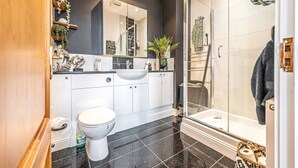 Une salle de bain moderne équipée de toilettes, d’un lavabo et d’une douche.