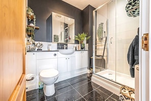 Ein modernes Badezimmer mit Toilette, Waschbecken und Dusche.