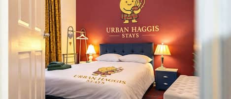 Ein Hotelzimmer mit einem Bett, zwei Nachttischlampen, einem Nachttisch, einer Kommode und einer Wand mit einer Zeichnung und Text.