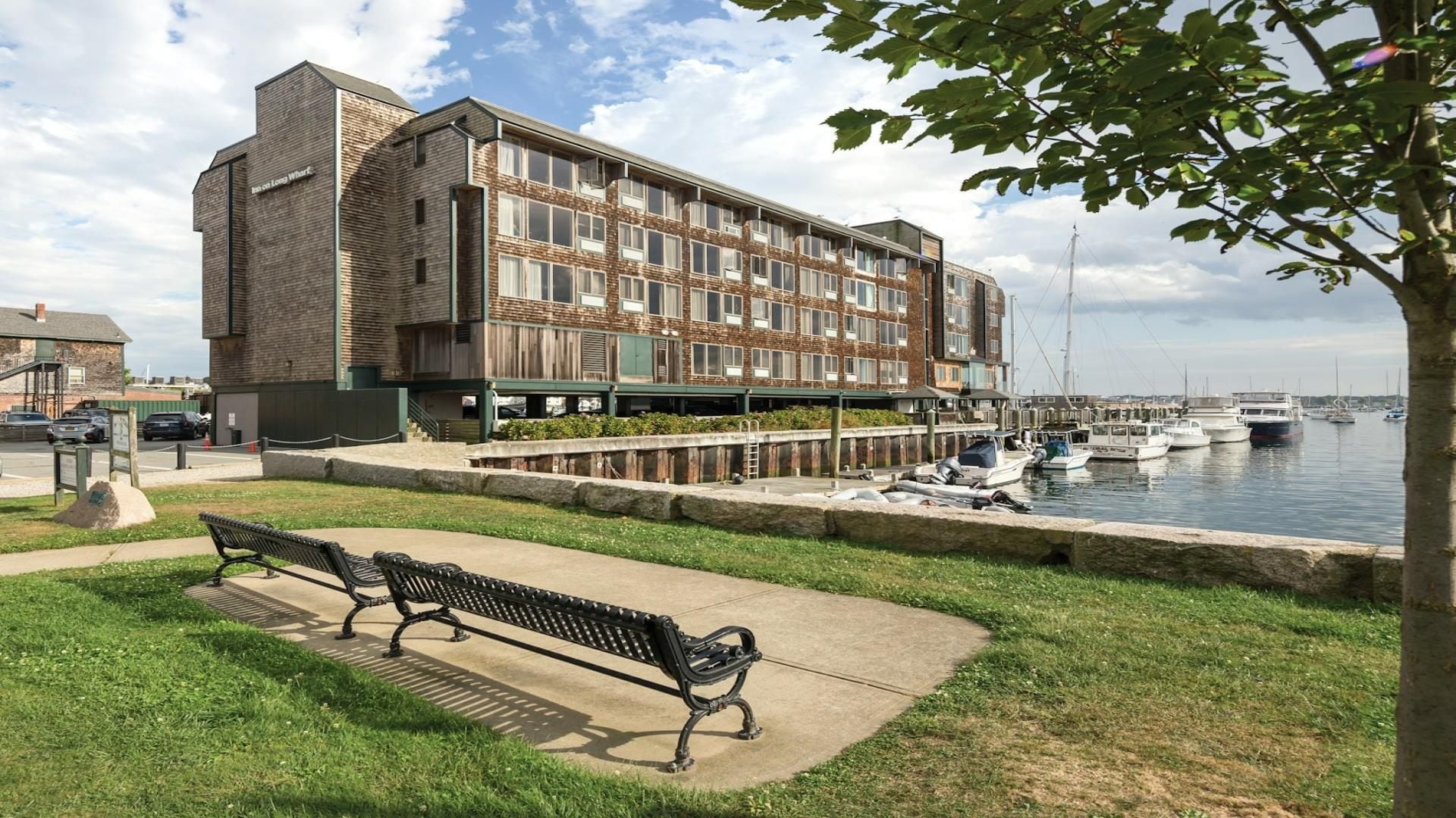 A waterfront building with a dock, a bench, and boats.
