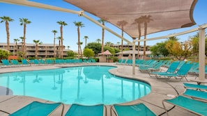 A swimming pool with sun loungers and palm trees. - Indio CA Coachella Valley Lazy River Studio - WorldMark Indio (Indio)