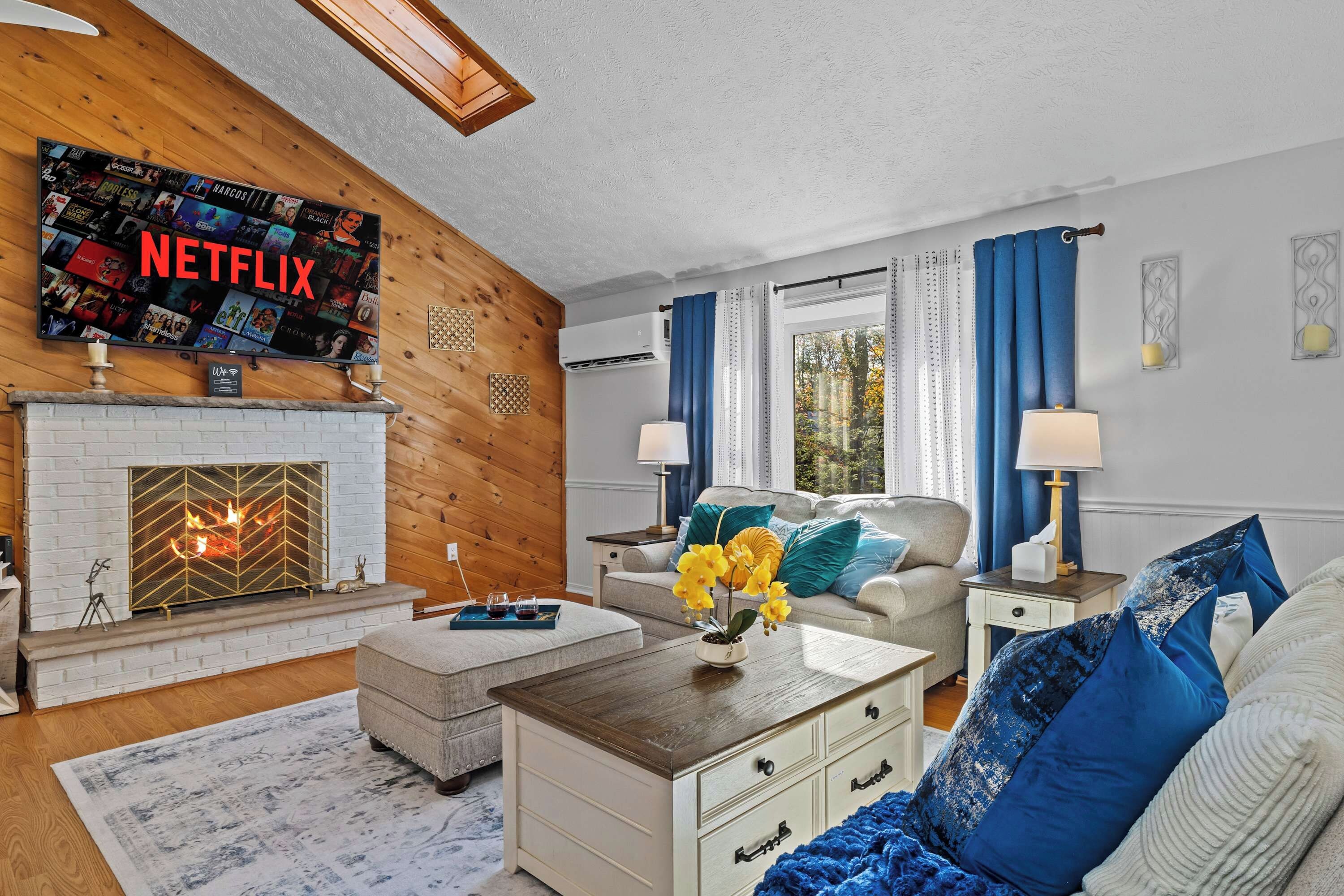 A living room with a fireplace, a television mounted on the wall, and a cozy seating area.