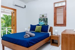 A bedroom with a bed, bedside table, and a window with shutters. - Condominio a solo unos pasos de la hermosa playa con gran piscina!! (Las Terrenas)