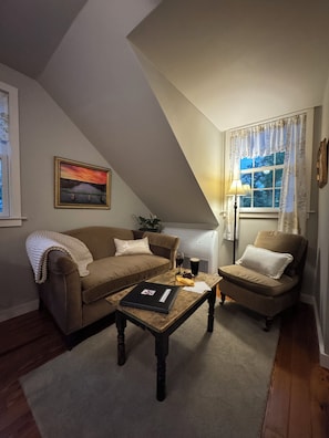 A cozy living room with a brown sofa, a wooden coffee table, and a lamp.