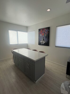 A modern kitchen with a central island, large windows, and a contemporary artwork on the wall. - Tranquil 1-bedroom house in beautiful Capitola near the beach (Capitola)