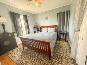A bedroom with a bed, a dresser, a nightstand, a lamp, and a ceiling fan. - A working waterfront cottage in Downeast Maine, trails and beaches nearby (Jonesport)