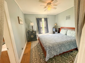 A bedroom with a bed, a nightstand, a dresser, a ceiling fan, and a window with curtains. - A working waterfront cottage in Downeast Maine, trails and beaches nearby (Jonesport)