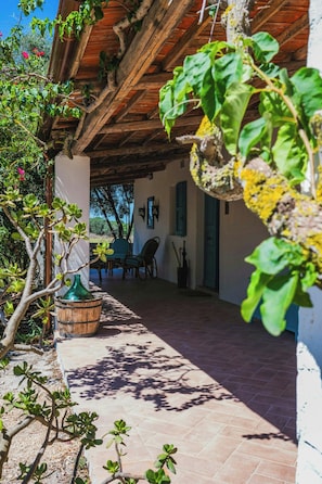 Ein Patio im Freien mit einer Holz-Pergola, einer Sitzecke und Blick auf die umliegende Landschaft.