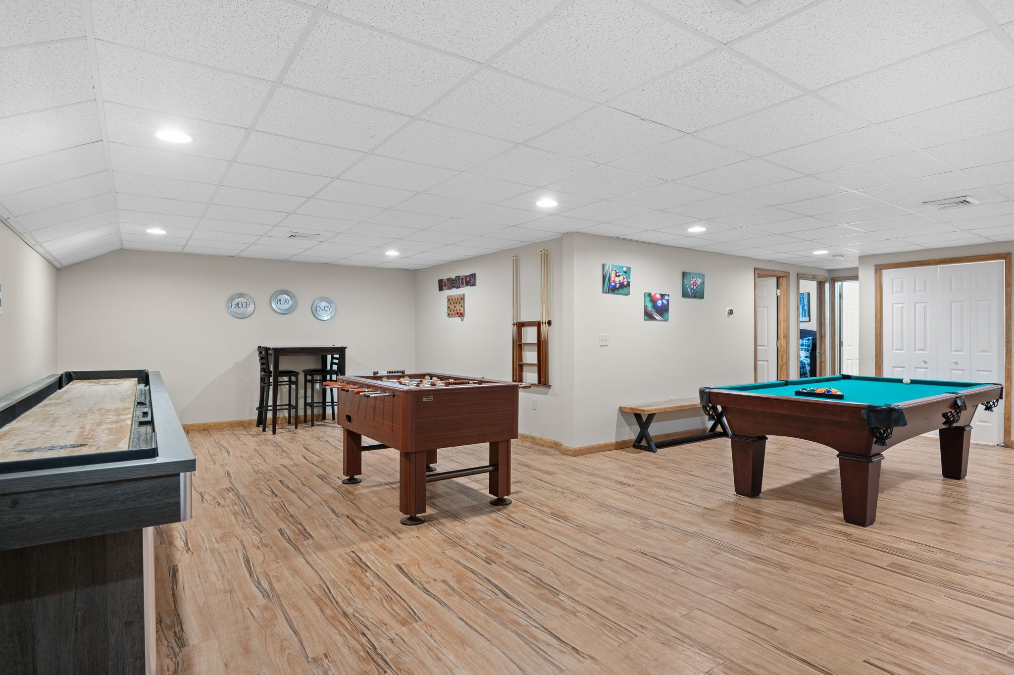 Een recreatieruimte met een tafelvoetbaltafel, een pooltafel en een biljarttafel.