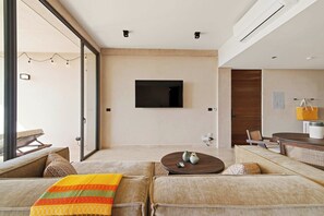 A modern living room with a flat-screen TV, a coffee table, and a sofa. - Sáasil: Tranquil Oasis w/ Golf course views (Playa del Carmen)