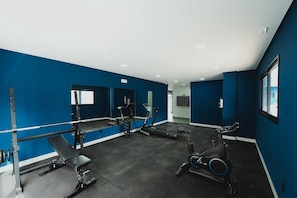 A gym with exercise equipment, a bench, and a mirrored wall. - Blue Life Stay 111 (Anápolis)