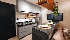 Una cocina moderna con gabinetes grises, una encimera negra y un horno empotrado.