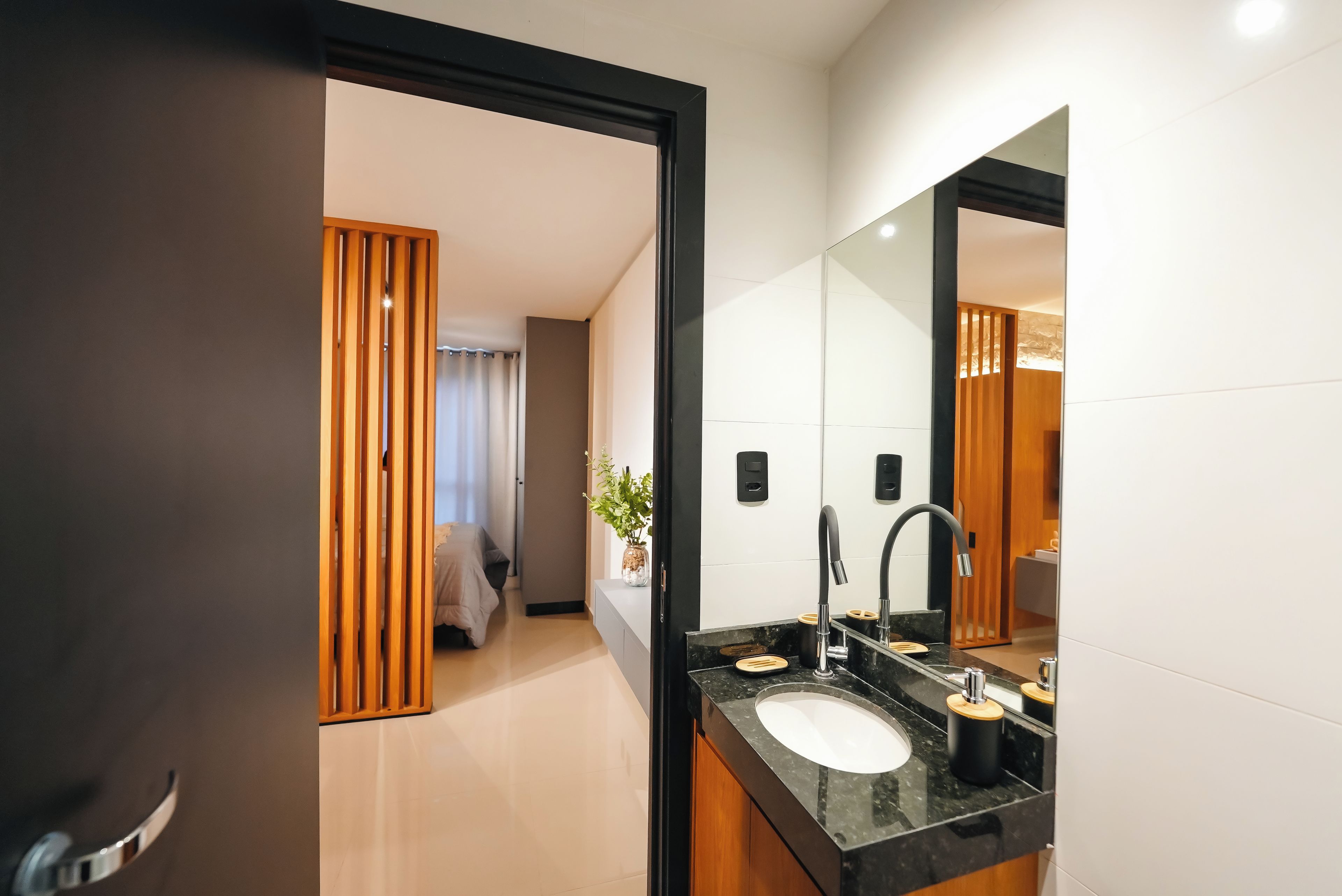 Un baño moderno con un espejo grande, un lavabo y una zona de ducha.