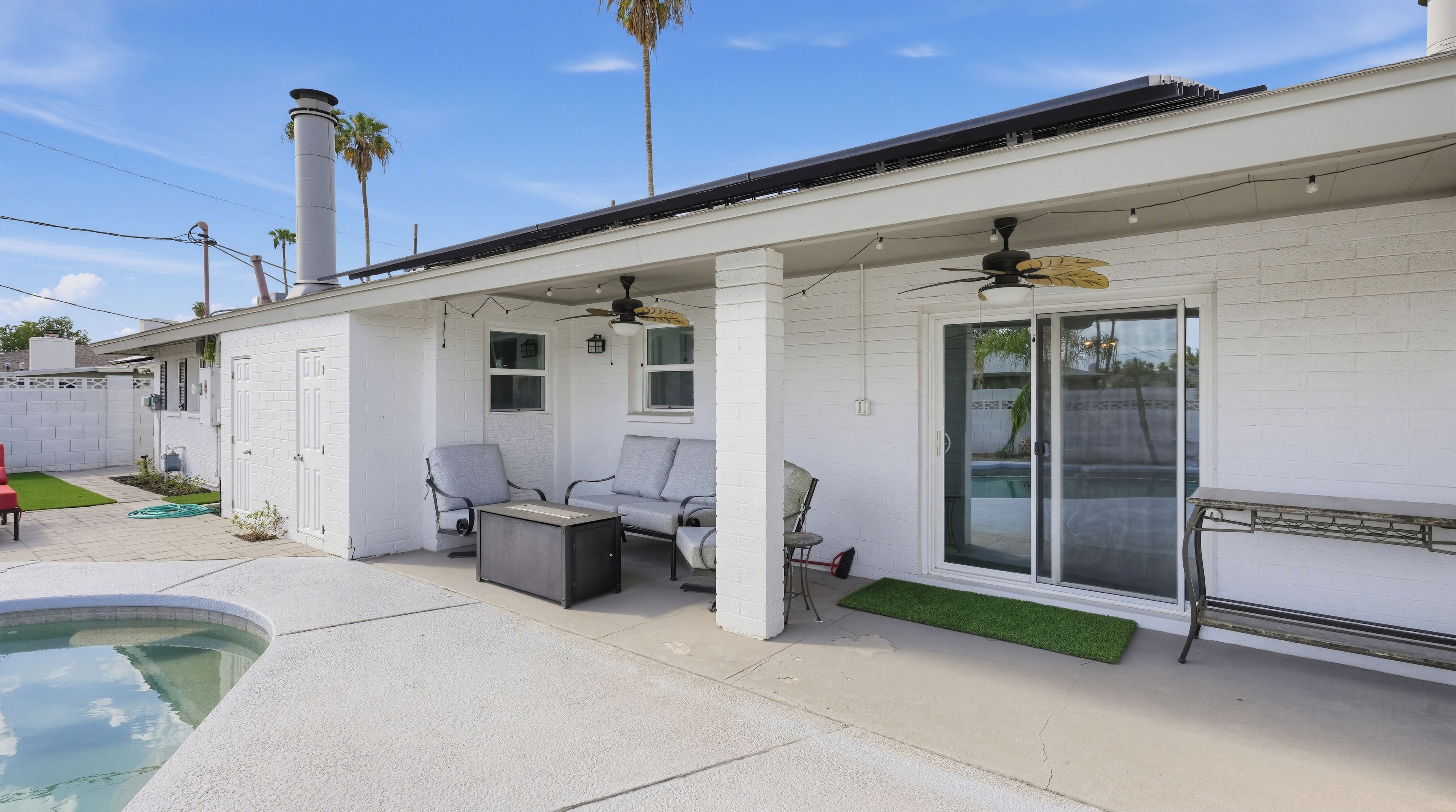 A covered patio area with a pool, outdoor seating, and a sliding glass door.