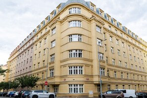 A multi-story building with a curved facade, multiple windows, and a no-entry sign. - Blueground | Vinohrady, view, nr park &  Náměstí Míru (PRG-112) (Prague)