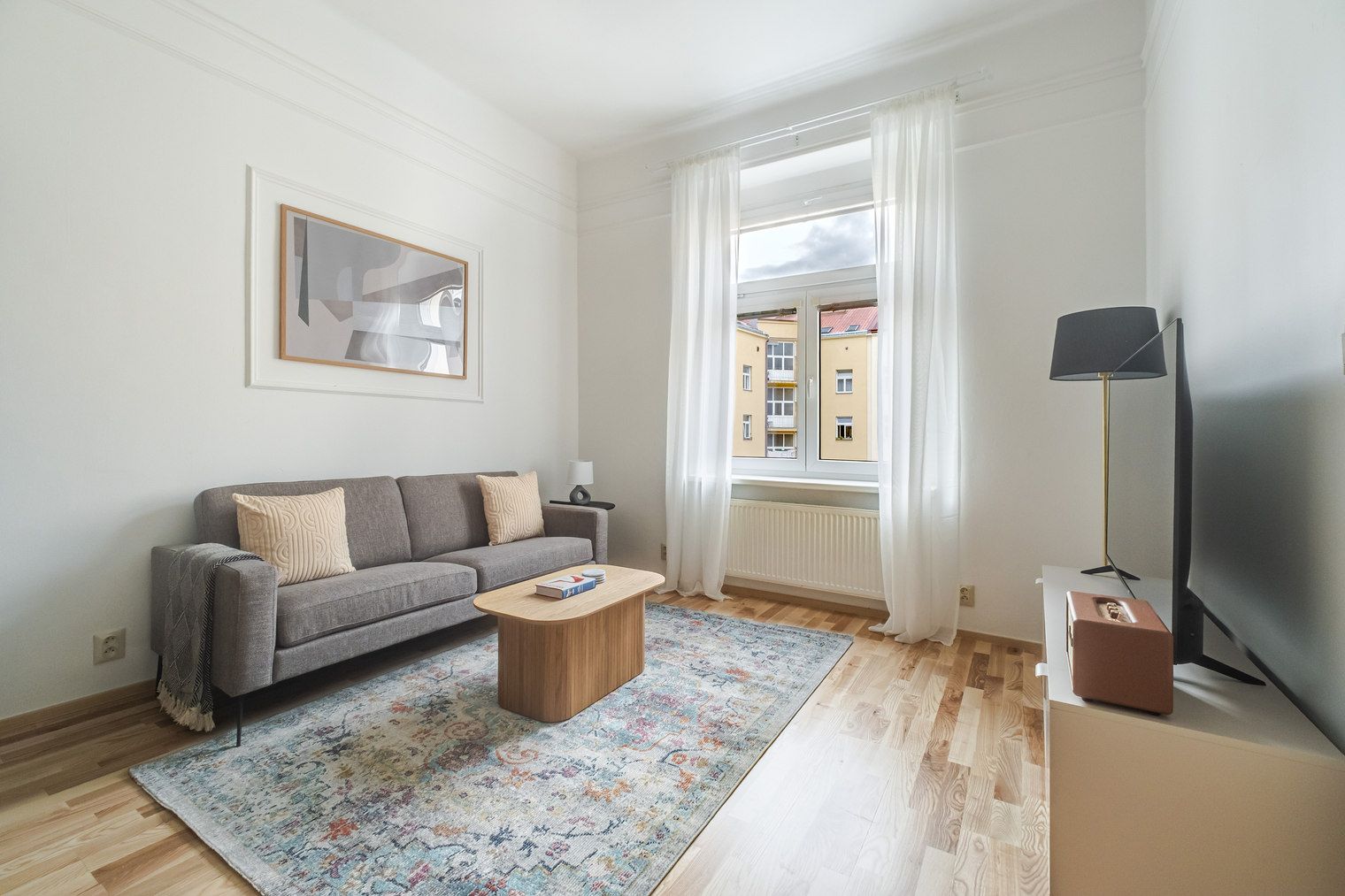 A living room with a sofa, coffee table, and a lamp.