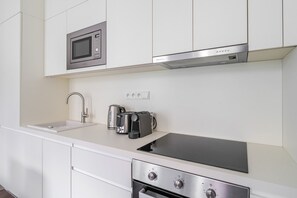 Eine moderne Küche mit integriertem Mikrowellenherd, Kaffeemaschine, Toaster und Backofen.