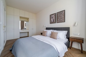 A bedroom with a bed, bedside tables, a wardrobe, and artwork on the wall. - Blueground | Vinohrady, view, nr Riegrovy Sady (PRG-124) (Prague)