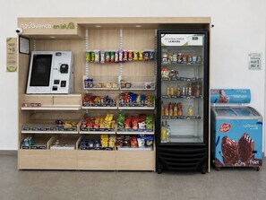 A self-service kiosk with a variety of packaged goods and a refrigerated display case. - Modern condo, 5-min walk to the beach · Pools, Gym & Coworking (Santa Marta)