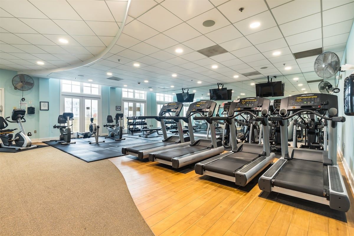 A gym with treadmills, exercise bikes, and weight machines.