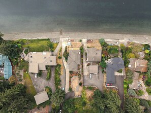 Ett flygbildsbild av ett bostadsområde med hus, en strand och en väg.