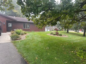 A residential property with a well-maintained lawn, a wooden deck, and a small garden area with a birdhouse. - Stupendous Lake Ida Home on the Water and close to Carlos Creek Winery. Lic2061 (Alexandria)