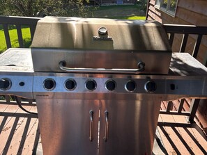 A Char-Broil gas grill with a handle and multiple vent holes, placed on a wooden deck. - Stupendous Lake Ida Home on the Water and close to Carlos Creek Winery. Lic2061 (Alexandria)