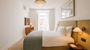 A hotel room with a bed, bedside lamps, a desk, and a window. - Ando Living - Tejo Palace - 201 (Lisboa)