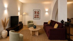 A modern living room with a flat-screen TV, a sofa, a coffee table, and a lamp. - Ando Living - Tejo Palace - 204 (Lisboa)