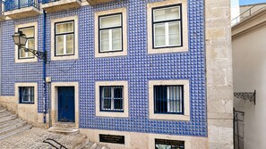 A building with blue tiled facade, multiple windows, and a blue door. - Ando Living - Tejo Palace - 204 (Lisboa)