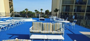 Zona de piscina al terrat amb gandules, una piscina petita i vistes als edificis circumdants.