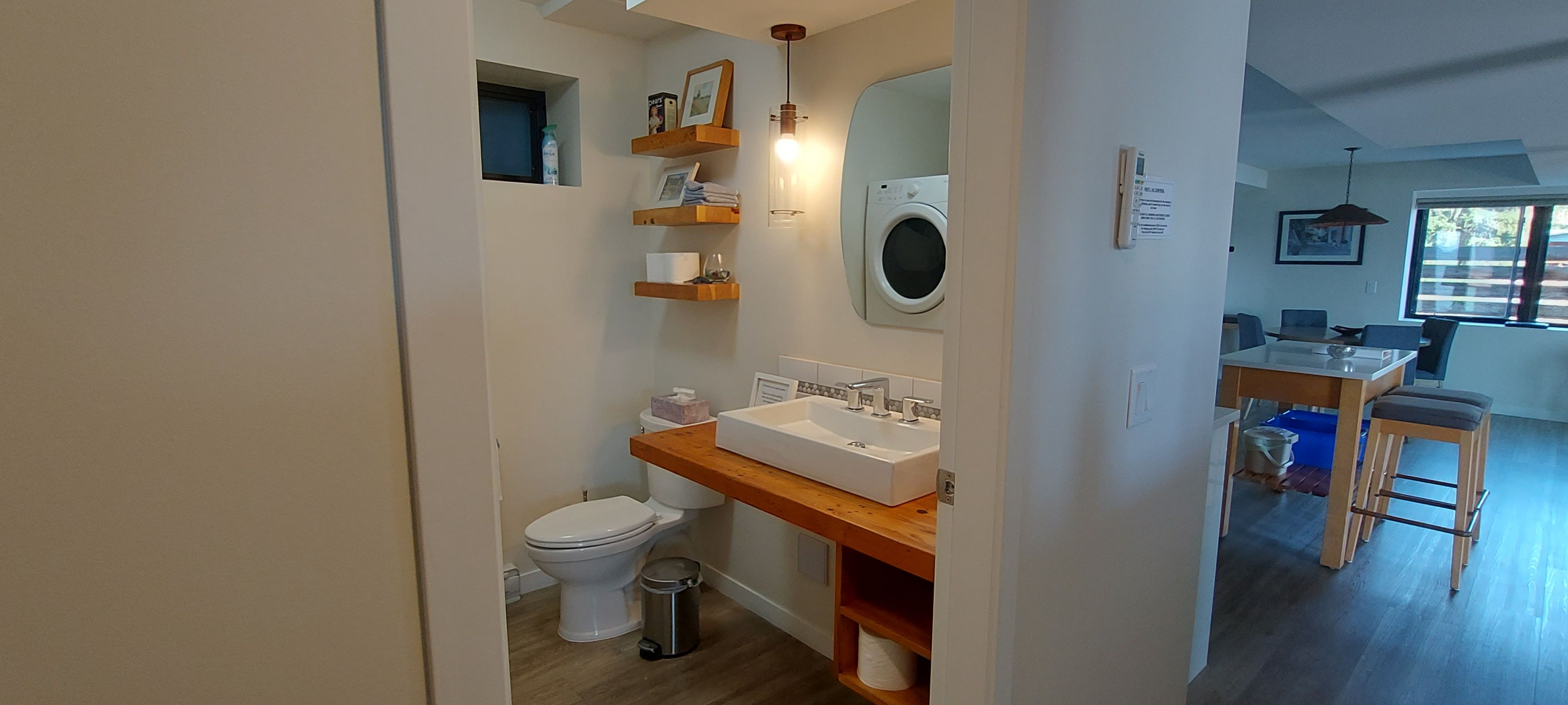 Une salle de bain moderne équipée de toilettes, d’un lavabo et d’un lave-linge.