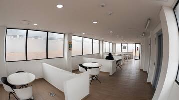 A modern office space with white partitions, round tables, and chairs.