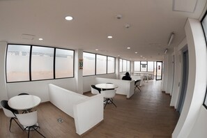 A modern office space with white partitions, round tables, and chairs. - Punto Chapinero / Gourmet District, Central Chapinero (Bogotá)