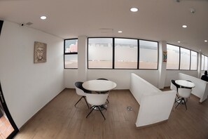Un interior moderno con una pared curva, ventanas amplias y un cuadro de Buda.