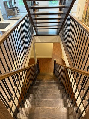 Un escalier en bois surmonté d’une verrière, menant à l’étage supérieur.