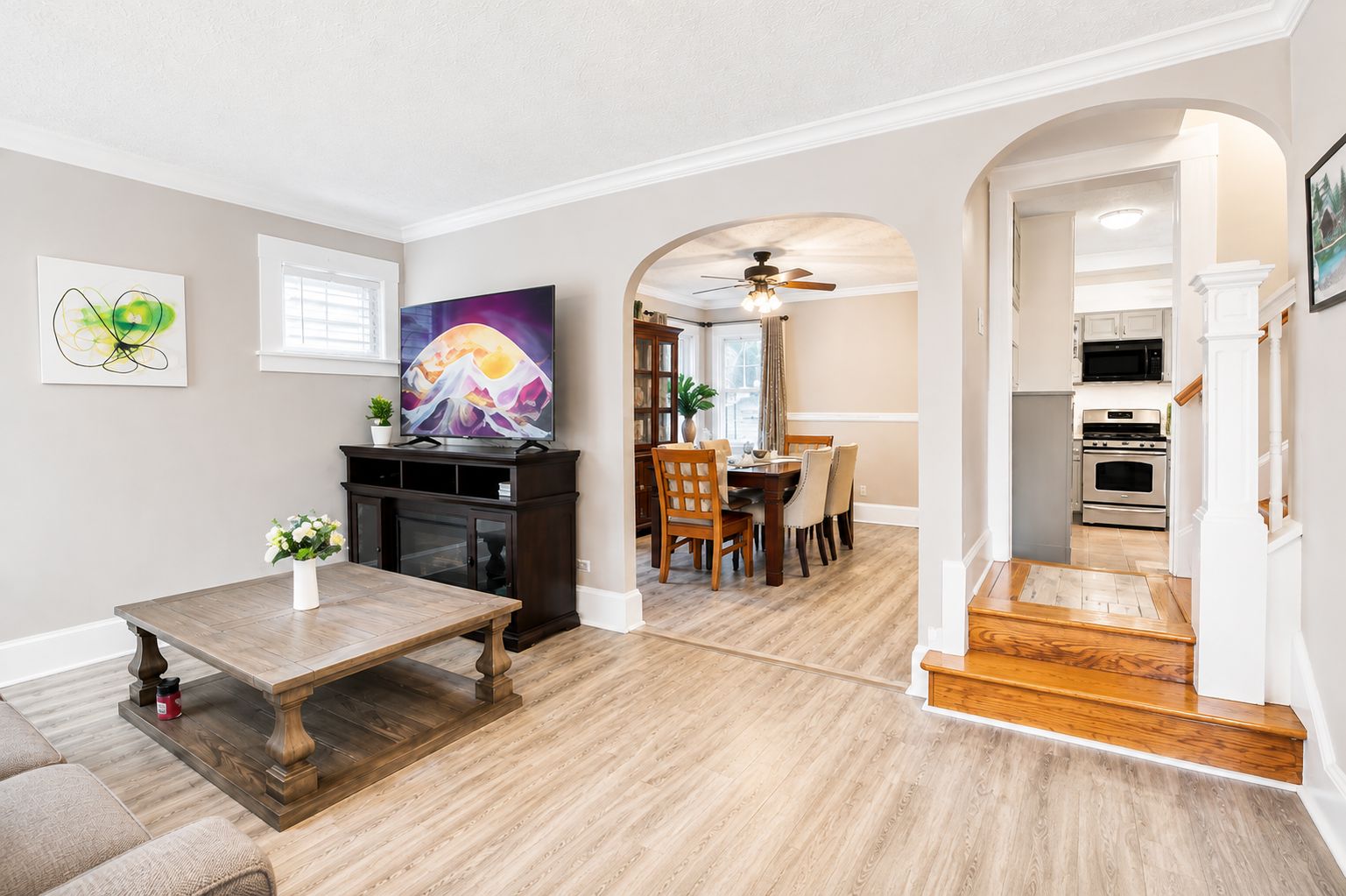 A modern living room with a fireplace, dining area, and kitchen.