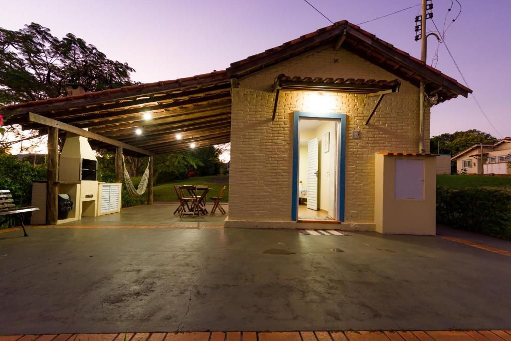 A small building with a covered patio area, a door, and a bench.