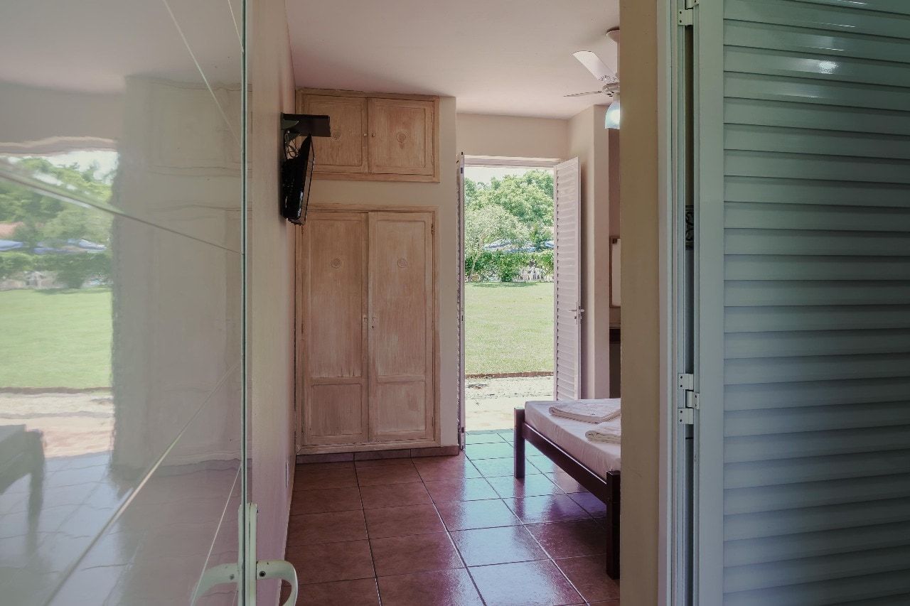 A room with a bed, a wardrobe, and a door leading to an outdoor area.