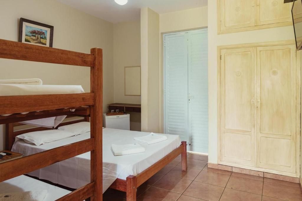 Una habitación con literas, una mesita de noche pequeña, un armario y una puerta.