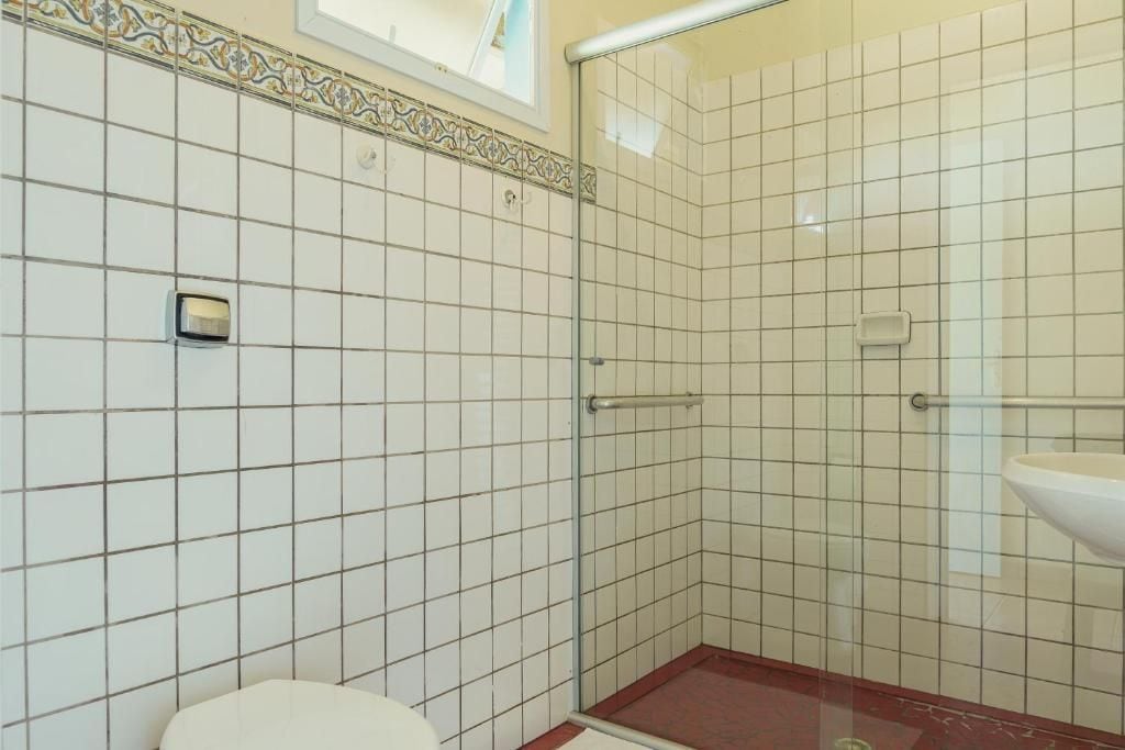 A bathroom with a shower, toilet, and sink.