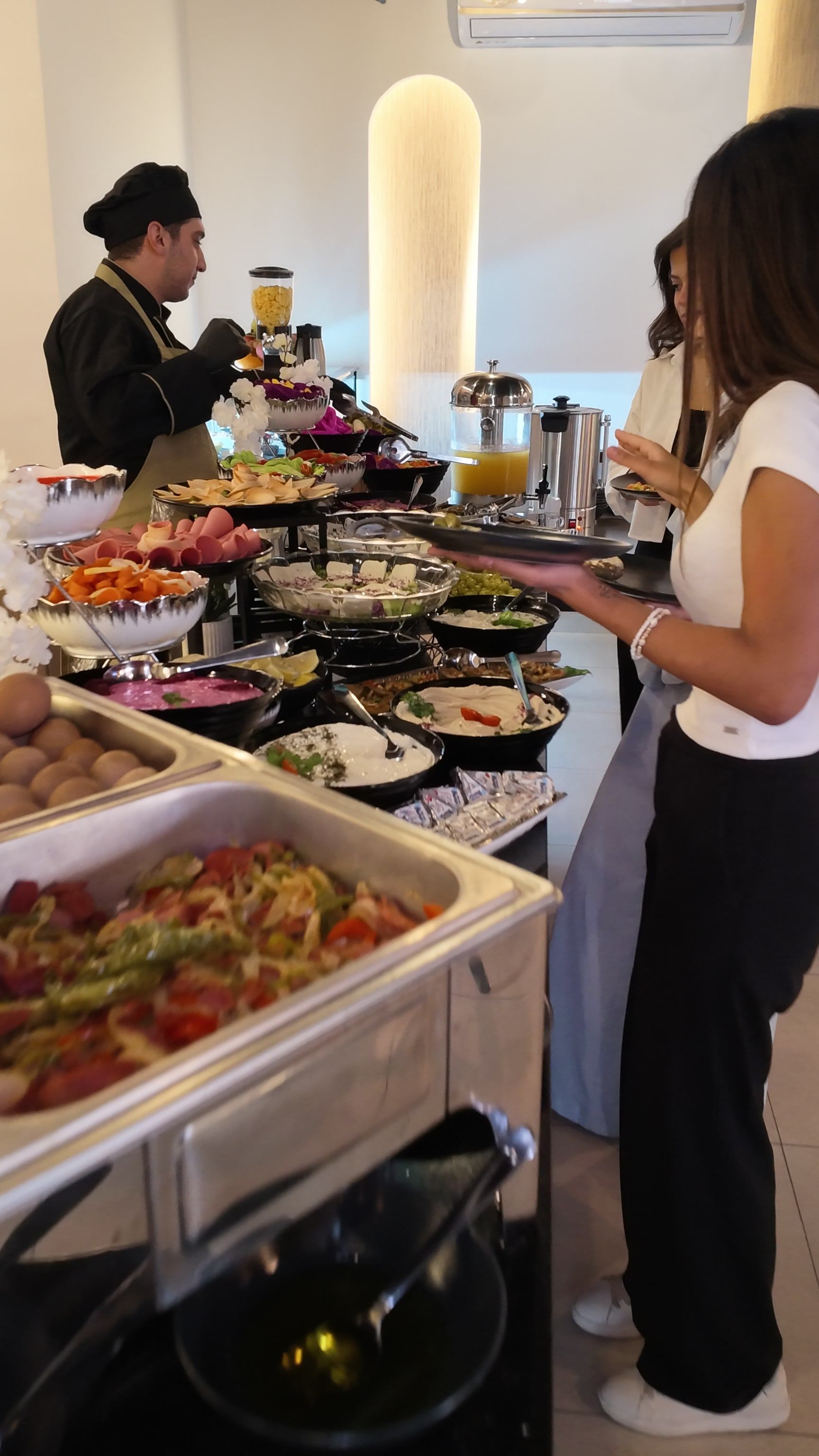 Buffet preparat amb diferents aliments i una persona que serveix.