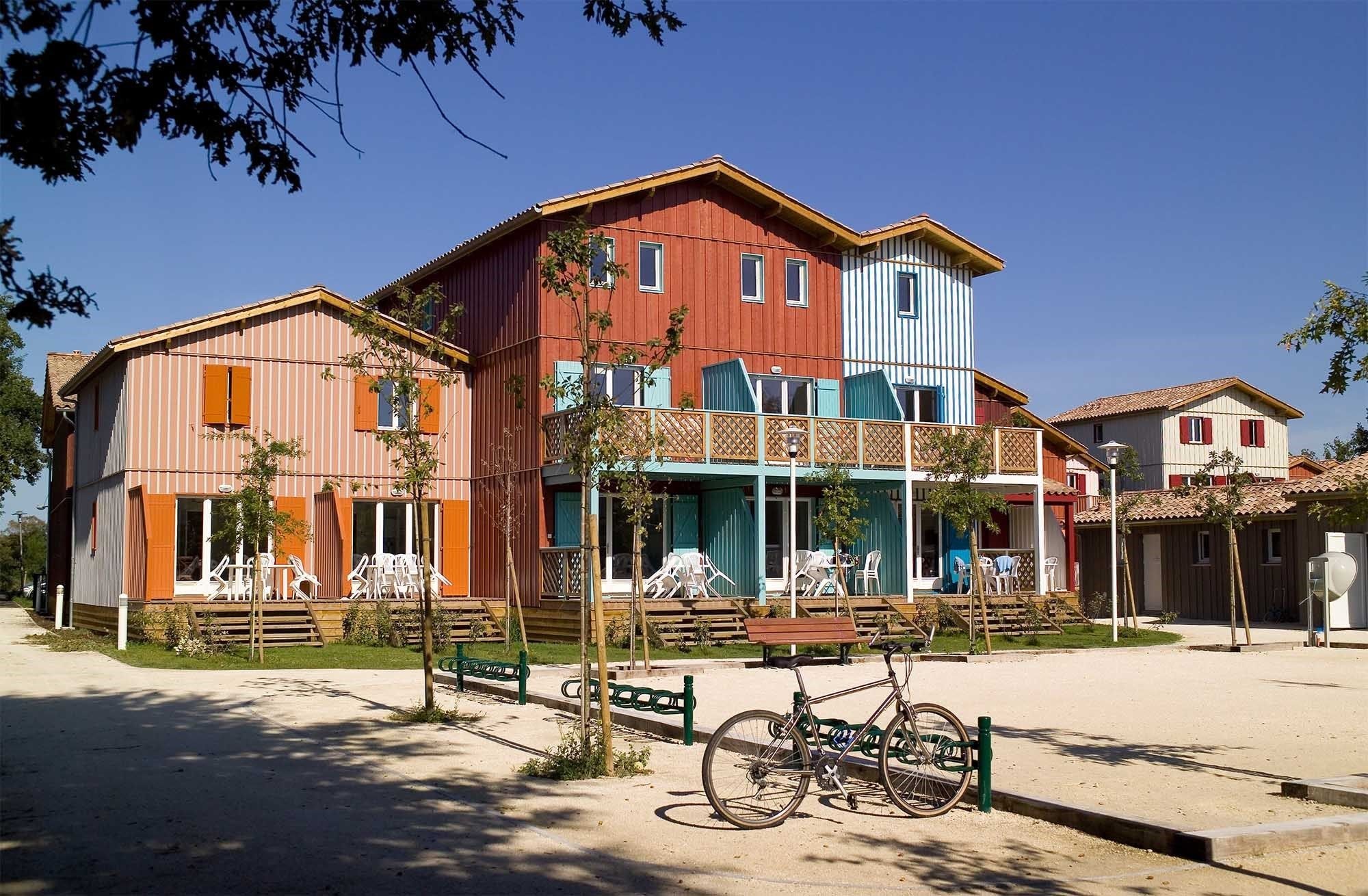Un edificio de varios pisos con balcón y zona de estar al aire libre.