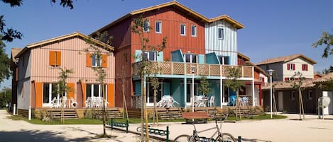 Un edificio de varios pisos con balcón y zona de estar al aire libre.