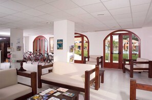 Un vestíbulo amplio con una mesa de centro, zona de estar y bicicletas.