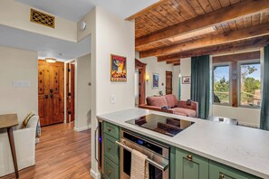 A modern kitchen with a built-in stove, green cabinets, and a large window offering a view. - Designer Santa Fe Condo, Communal Pool and Hot Tub (Santa Fe)