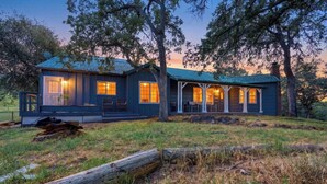 A two-story house with a porch, large windows, and a metal roof. - Agate Ranch | 2 BD + Views + EV + Walk to River (Three Rivers)